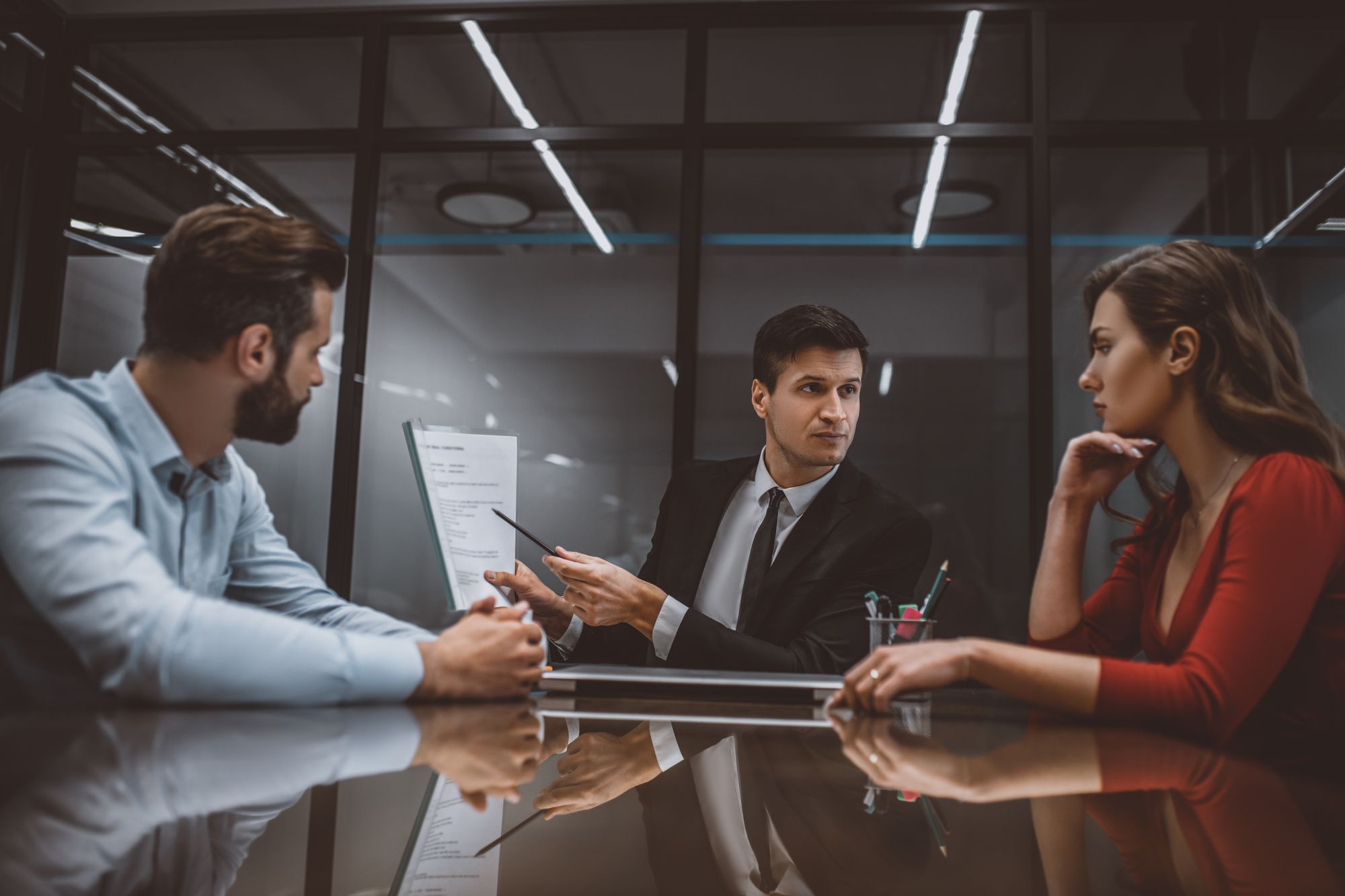 Divorcing spouses reviewing a proposed settlement agreement in a formal conference room during divorce mediation; choosing between mediation vs. litigation in a Chicago divorce.