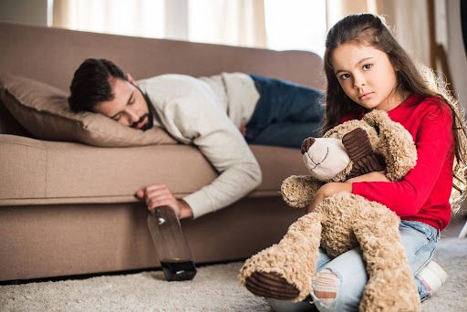 A parent with a bottle of alcohol asleep on the couch in front of a young daughter. Can substance abuse affect child custody?